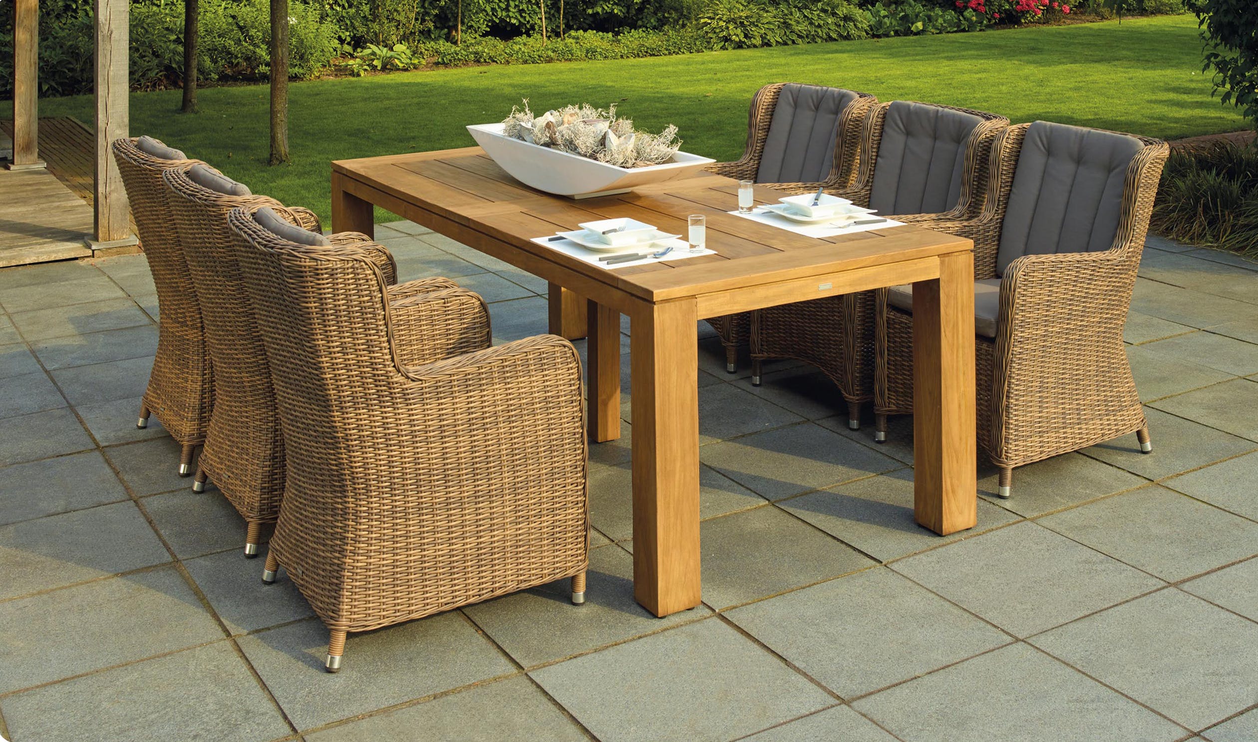 wooden garden table with six wicker chairs.