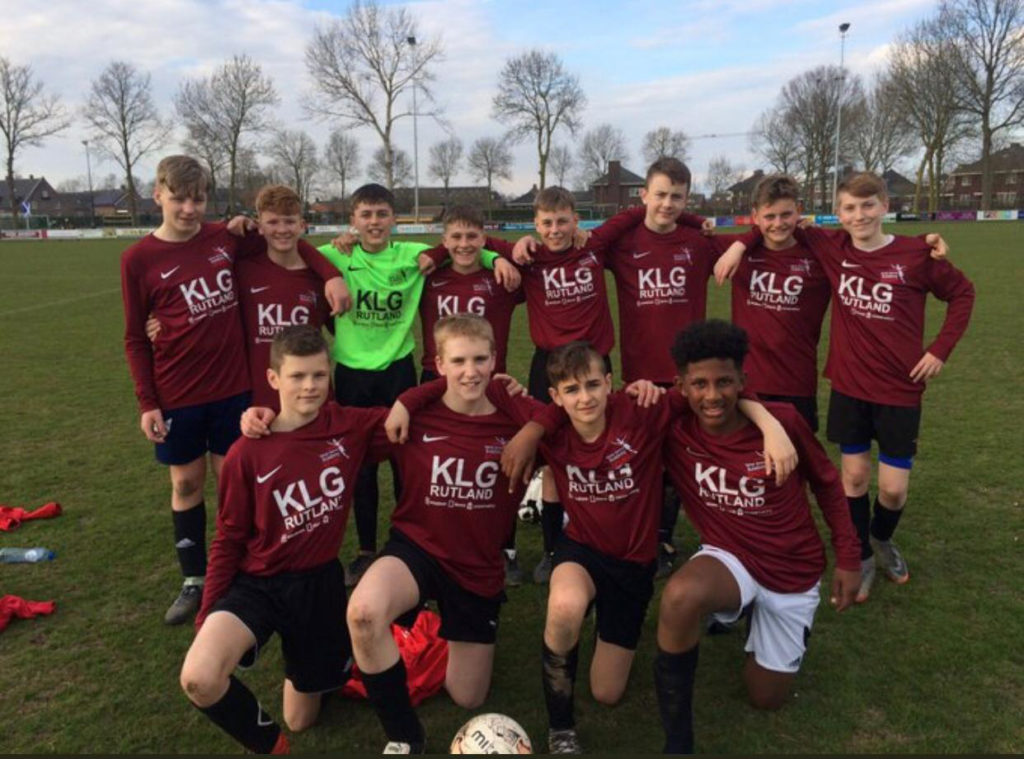 The Ilkeston RUFC under sixteens line up in a team photo, displaying the KLG Rutland logo on their shits.