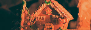 Beautiful gingerbread house with Christmas tree in orange lighting, showing creativity with candy cane roof.