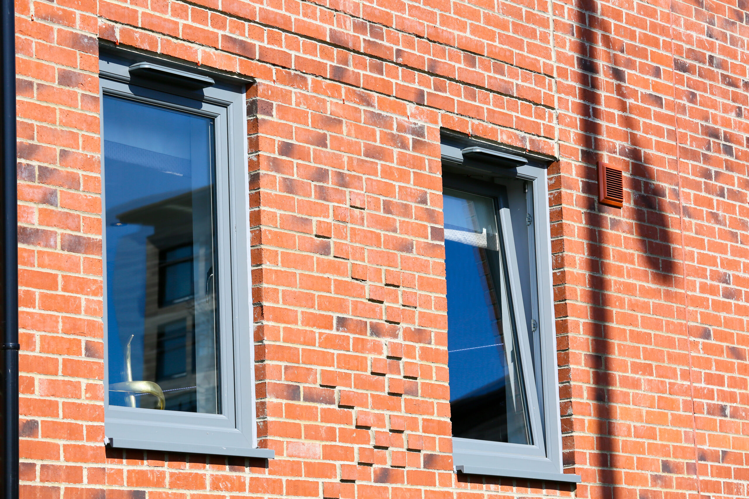 Grey tilt and turn windows opened in the sun